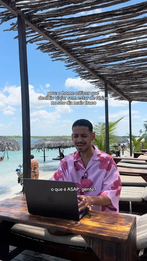 Reel do Yugui numa praia, trabalhando no notebook, com o texto pov: o home officer que decidiu viajar sem estar de férias no seu dia mais fraco